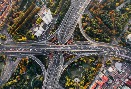 Aerial view of a highway cloverleaf interchange in fall foliage.