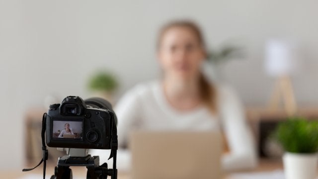 Mujer compartiendo su experiencia profesional frente a cámara en entorno de oficina