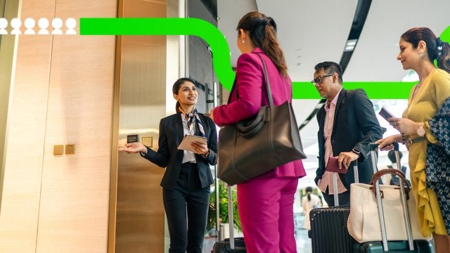 Equipo de recepción recibe a asistentes corporativos durante su llegada a un evento de negocios, coordinando el registro y acceso al recinto.