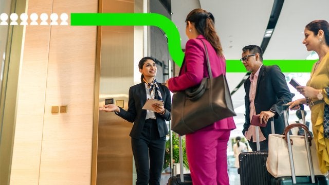 Equipo de recepción recibe a asistentes corporativos durante su llegada a un evento de negocios, coordinando el registro y acceso al recinto.