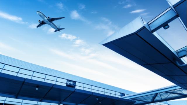 Plane taking off at airport with the terminal in the foreground
