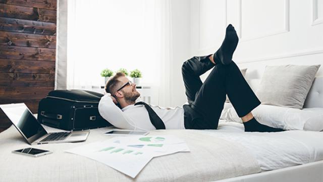 Male business traveller lying on hotel bed