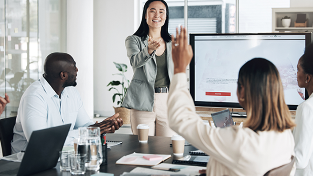 A lady smiling and heading up a meeting read the consolidation case study