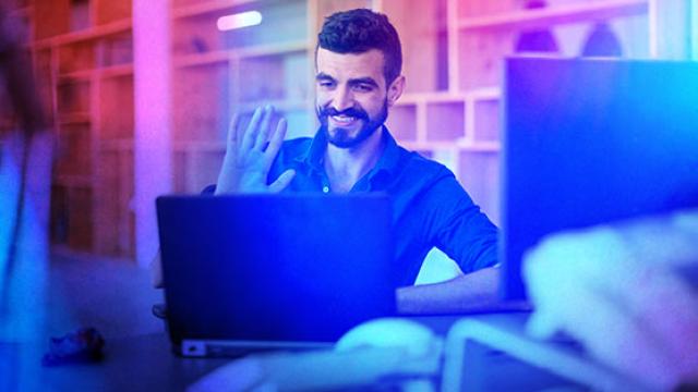 Man waving at laptop hosting virtual event