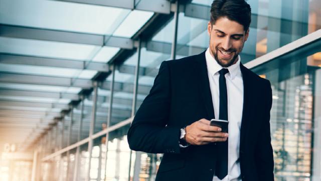 Businessman looking at phone happily