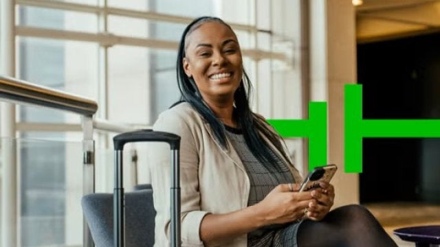 Lady smiling at the airport, booking our webinar