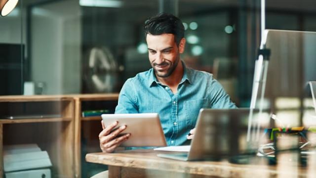 Man smiling at an iPad