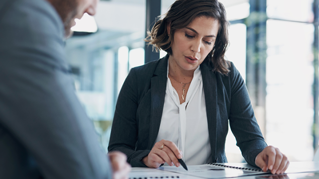 A woman reviewing a business travel programs with a colleague 