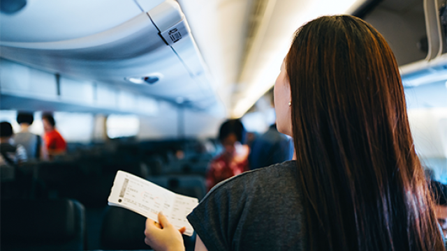 woman holding a ticket, boarding a plane