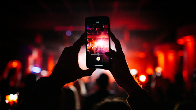 person recording a concert on their phone