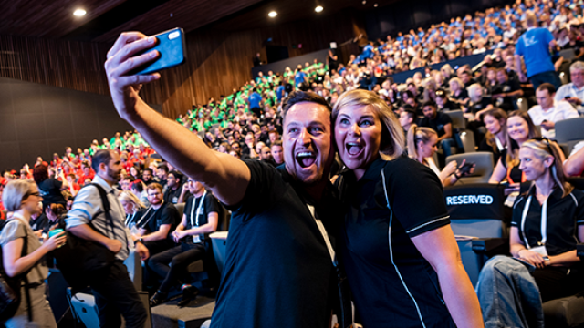man at an event taking a selfie