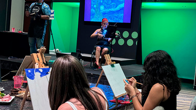 Presentador del event paint & wine explicando 