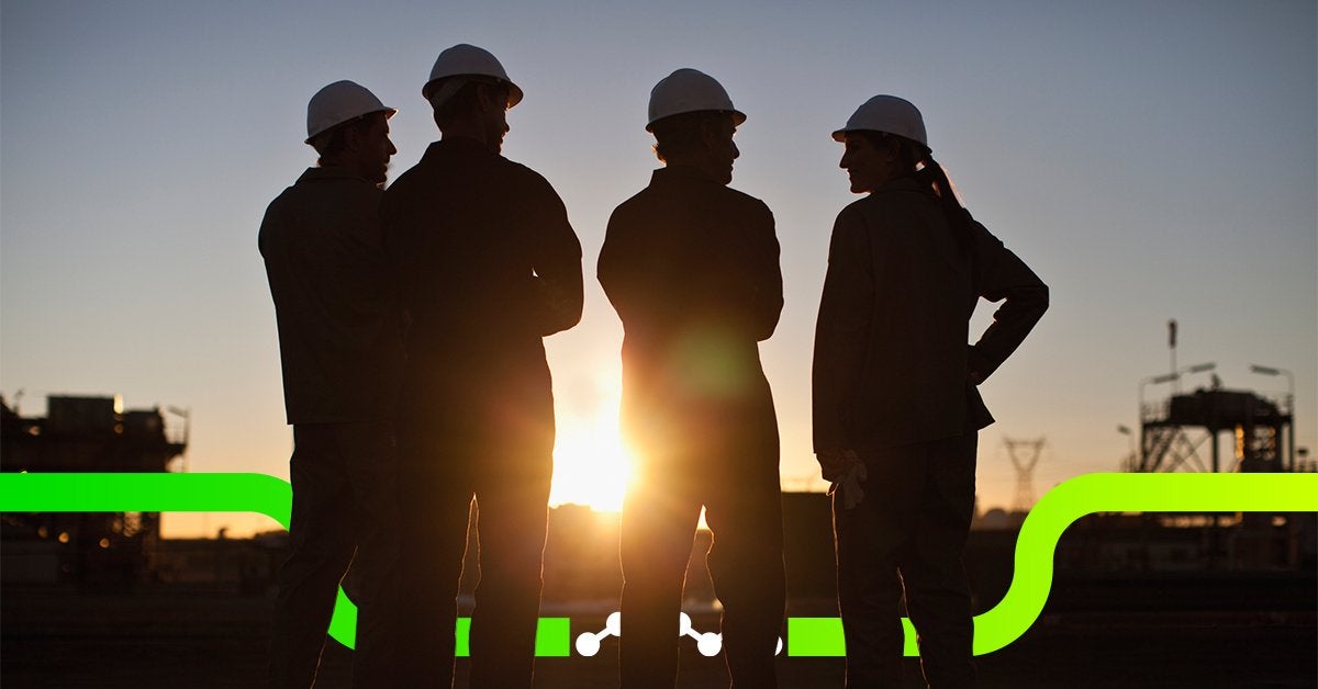 Grupo de profesionales observando una instalación industrial al atardecer durante una etapa de expansión empresarial.