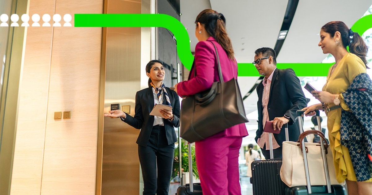 Equipo de recepción recibe a asistentes corporativos durante su llegada a un evento de negocios, coordinando el registro y acceso al recinto.