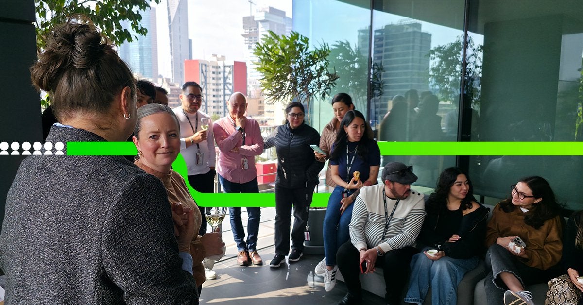 Networking corporativo durante un desayuno empresarial en una terraza con vista urbana, donde profesionales conversan y construyen relaciones de negocio.