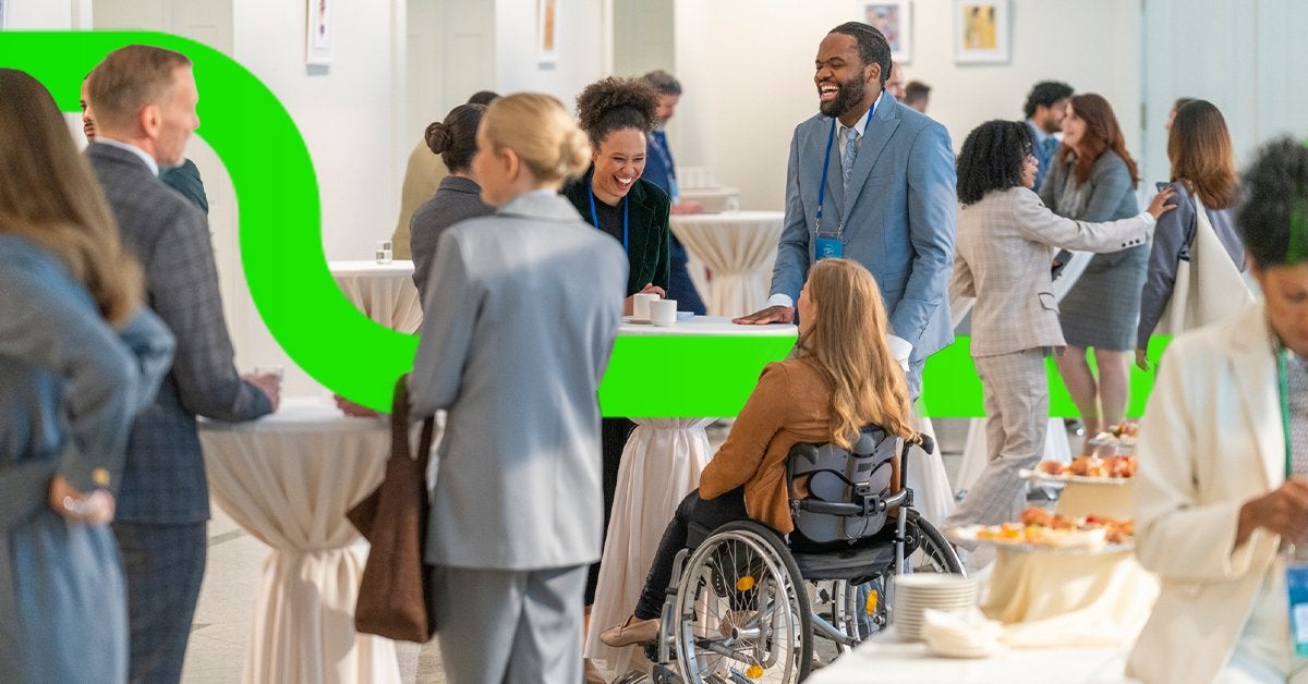 Profesionales interactúan durante un evento corporativo inclusivo, fomentando la participación y las conexiones entre asistentes de diferentes perfiles. 