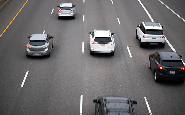 Multiple cars driving on a busy highway with visible lane markings.
