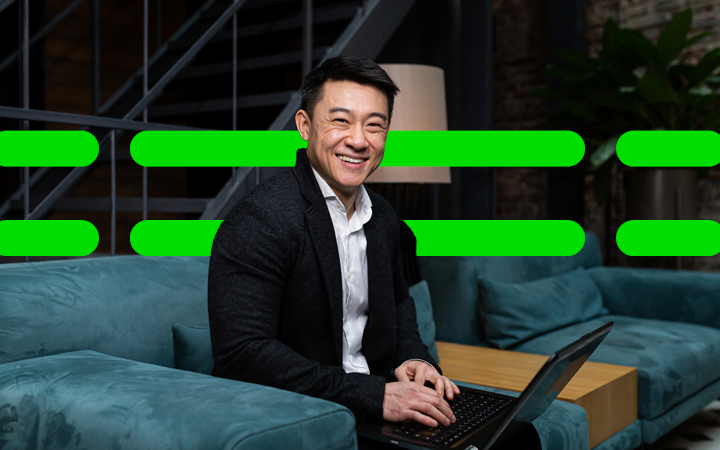 Man on  laptop looking at the camera smiling