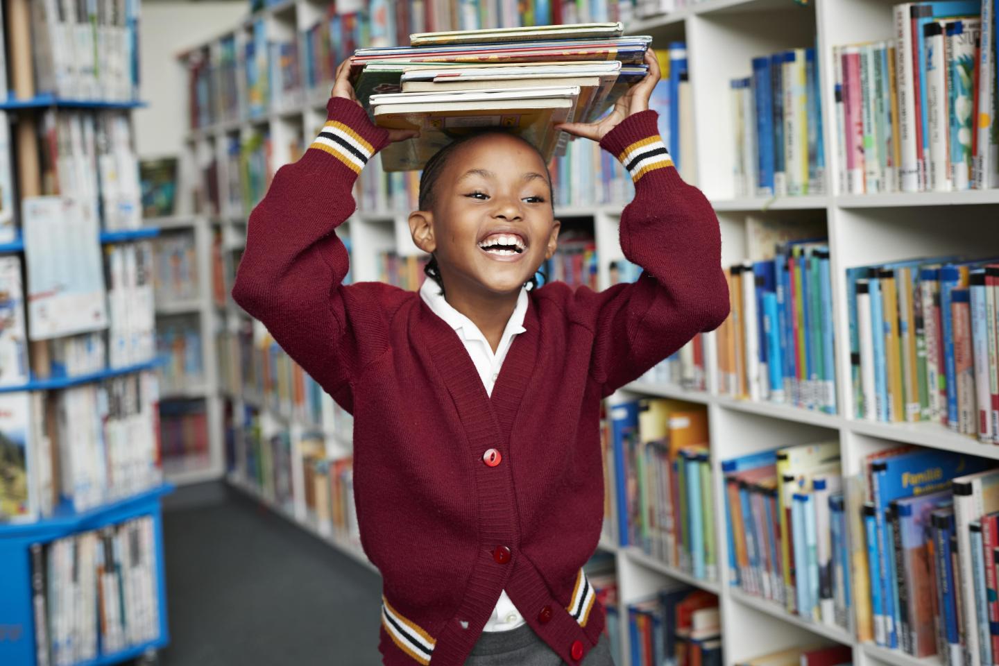 Boy with books in library