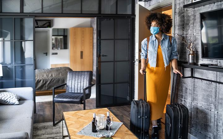 Women walking into hotel room with mask on