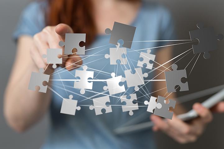 women holding a tablet with puzzle pieces overlayed