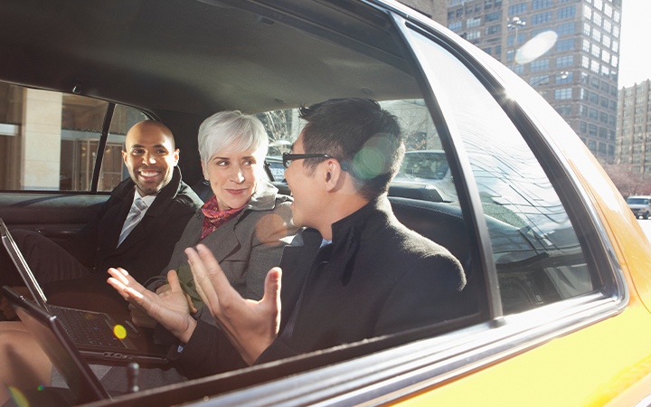people speaking in the back of a taxi