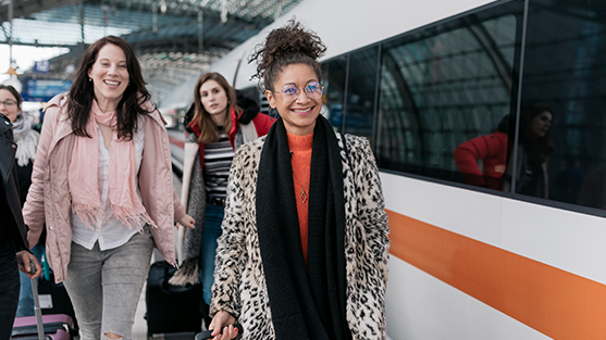 3 women walking on a train platform