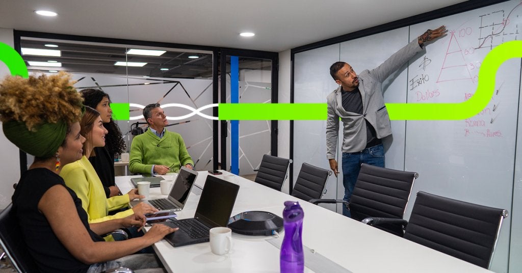 Ejecutivo explicando objetivos y métricas en reunión corporativa previa a un evento.