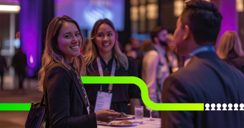 Asistentes interactuando y haciendo networking durante un evento corporativo, impulsando la conexión y la participación en tiempo real.