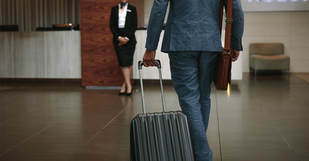 Ejecutivo llega a un hotel de negocios para realizar su registro durante un viaje corporativo.