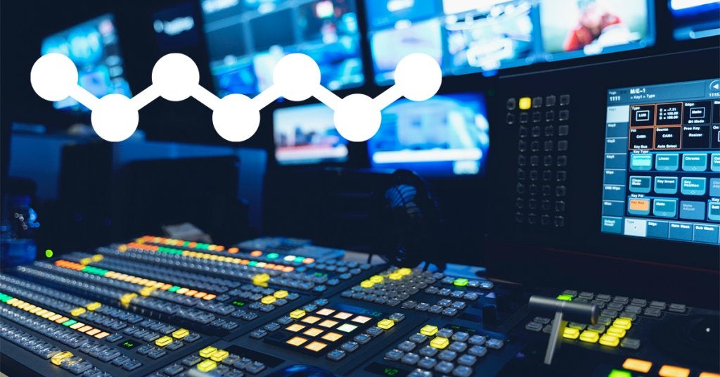 Consola de producción audiovisual con múltiples monitores y sistema de control operando en tiempo real durante un evento corporativo.