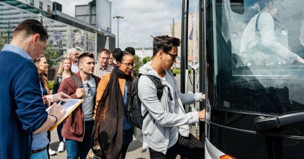 Asistentes llegan a un evento corporativo que genera emisiones asociadas a viajes, transporte, hospedaje y producción.