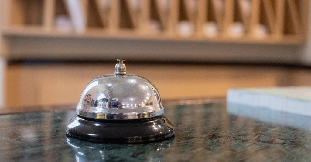 Campana de recepción en hotel corporativo preparada para la atención de huéspedes y viajeros de negocios.      