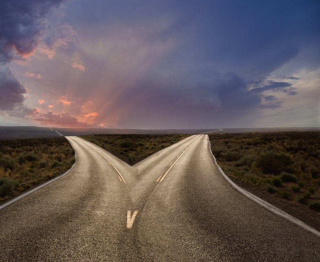 Carretera que se divide en dos direcciones, representando decisiones estratégicas con resultados diferentes.