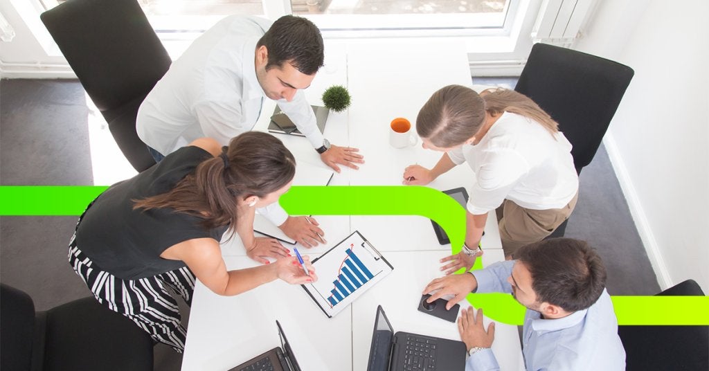 Asistentes caminando en evento corporativo con iluminación dinámica y ambiente profesional.