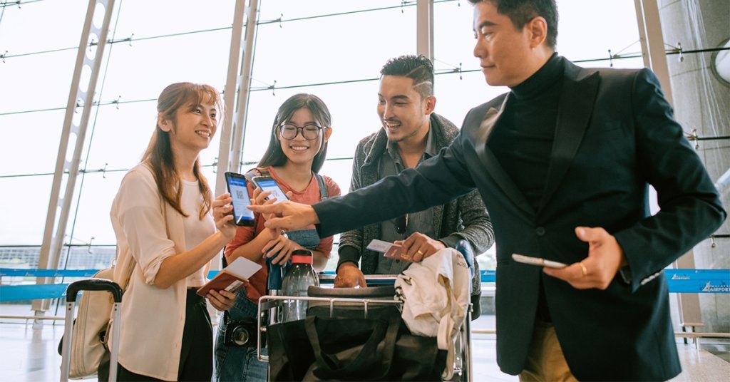 Participantes utilizan herramientas digitales de identificación y acceso durante un proceso de registro en una terminal de viaje.