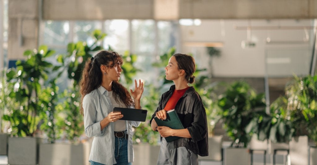  Profesionales conversando durante un encuentro de negocios en un espacio para eventos corporativos.