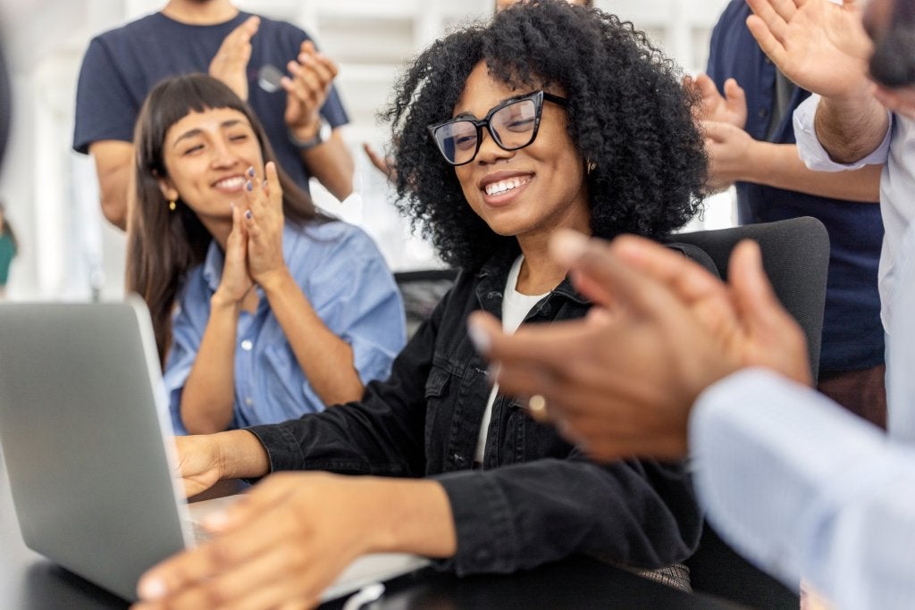 Equipo de trabajo analizando información y celebrando decisiones sobre gestión de viajes corporativos