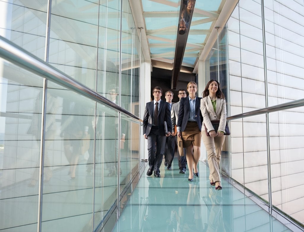 Equipo ejecutivo avanza por un corredor corporativo después de definir una dirección estratégica.