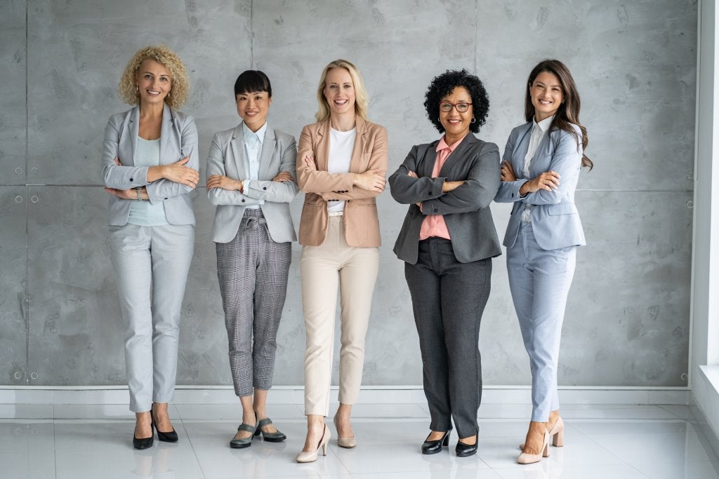 Grupo de mujeres líderes en entorno corporativo representando diversidad y liderazgo profesional