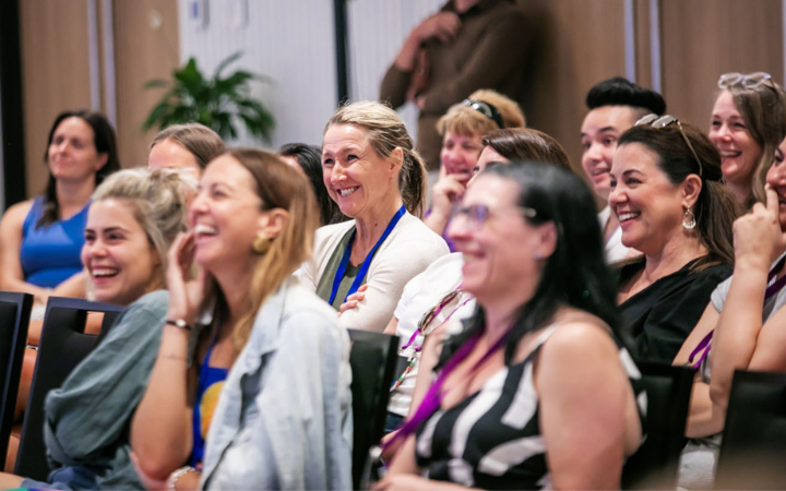 A conference audience laughing together