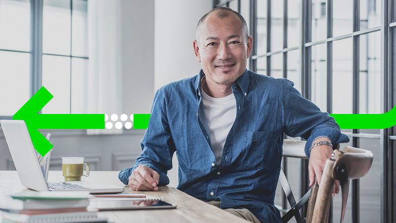 Man at desk smiling for camera