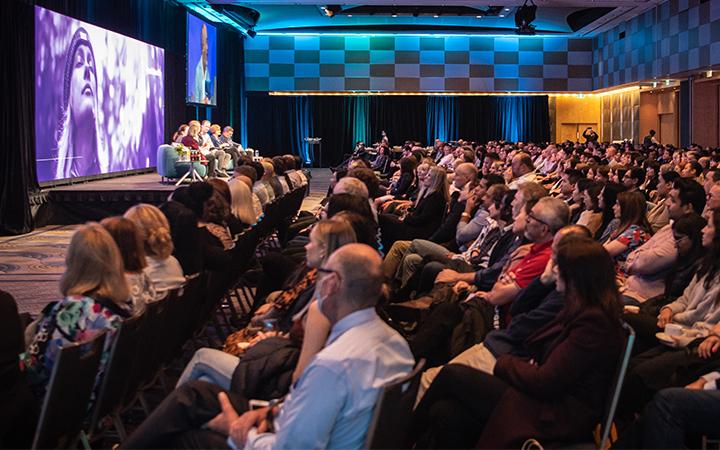People in audience watching speaker