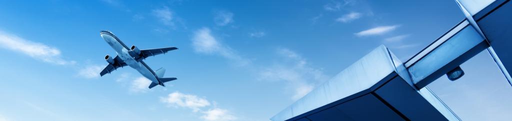 Plane taking off at airport with the terminal in the foreground