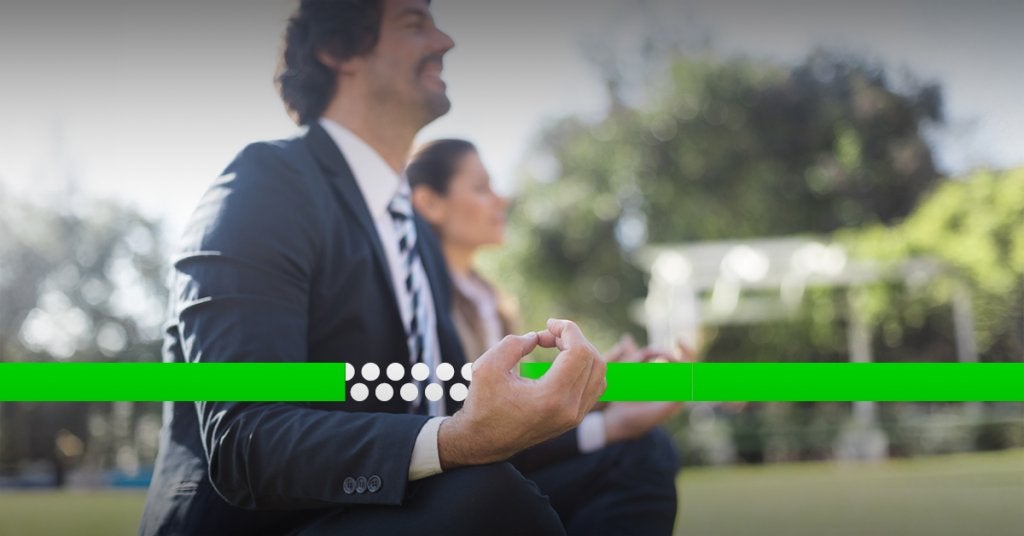 Ejecutivos en un entorno tranquilo, practicando una pausa consciente como parte del bienestar y la claridad mental en viajes corporativos.