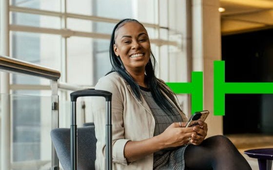 Lady smiling at the airport, booking our webinar