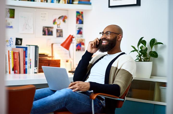 Man working and talking on phone smiling.