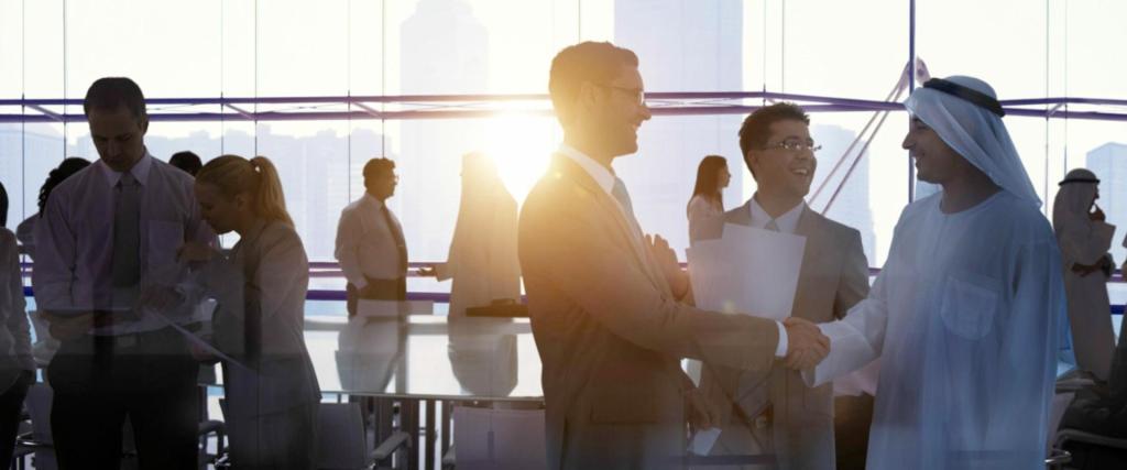 Group of businessman meeting greeting in an office shaking hands with middle east person