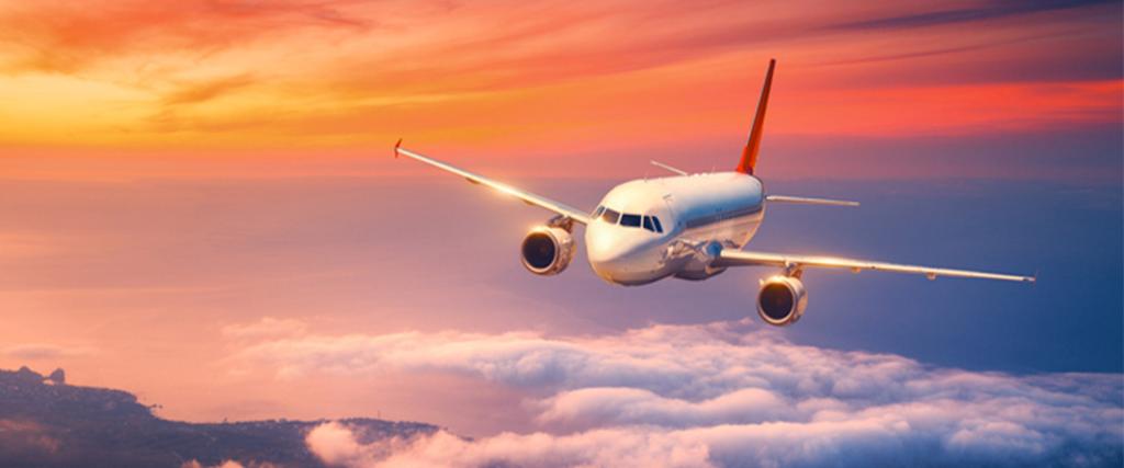 front view of aeroplane flying in an orangy blue sky