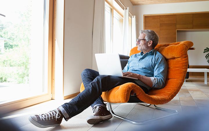 Man with laptop looking out window_FCM